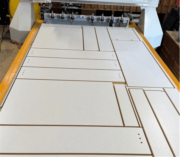 Nested cabinet parts cut and labeled on the CNC router bed